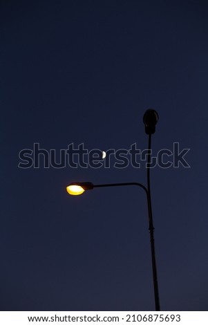street lamp against the background of the crescent moon and the night sky