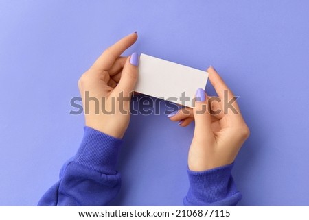Womans hand holding business card on purple background. Business work template mockup