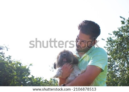 young man playing with dog at park