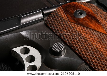 Firearm close up with rosewood grips Royalty-Free Stock Photo #2106906110