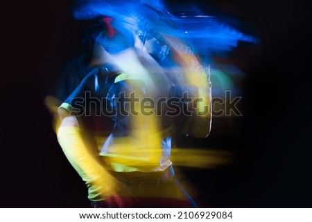 Futuristic character in a bright stylized outfit, photo with neon colors. A fantastic character, a cyber mercenary, long exposure photo with blur effect