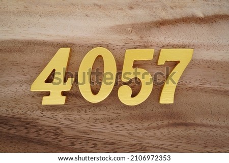 Golden Arabic numerals 4057 on a dark brown to white wood grain background.