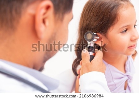 Doctor examines ear with otoscope in a pediatrician room. Medical equipment