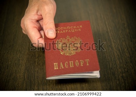 The woman at the table gives the Russian passport for verification. Inscription in Russian: Passport of Russia. Royalty-Free Stock Photo #2106999422