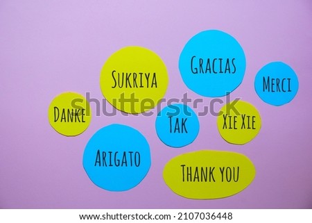 Thank you note in different languages texts on colorful paper background. 