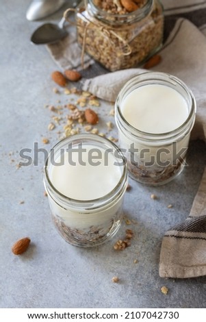 Healthy breakfast, yogurt parfait. Yogurt with homemade almond granola on a gray concrete background. 