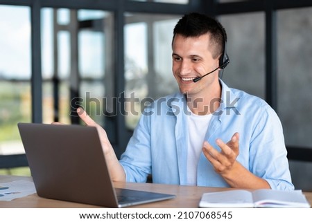 Happy caucasian employee call center, businessman, customer support manager wearing with headset using laptop computer for virtual meeting consulting client at on video call Royalty-Free Stock Photo #2107068545