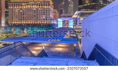 New promenade with stairs on gate avenue located in Dubai international financial center night timelapse. It is connecting all skyscrapers in the DIFC.