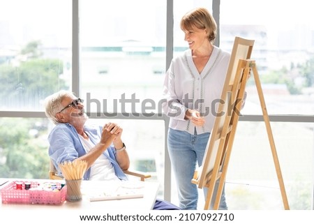 senior couple artist talking about painting work in office 