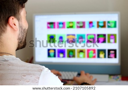 Man in front of computer looking for nft - non fungible token