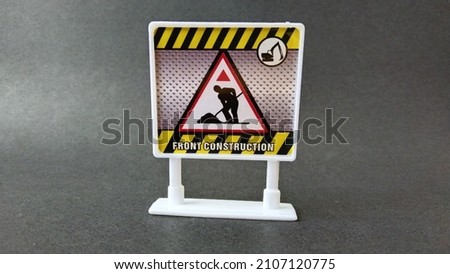 front construction notice sign toy on black background