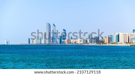 Abu Dhabi coastal cityscape with tall skyscrapers towers under clear blue sky on a daytime