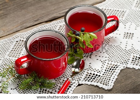 Siberian blueberry and juniper branches tea in red cups