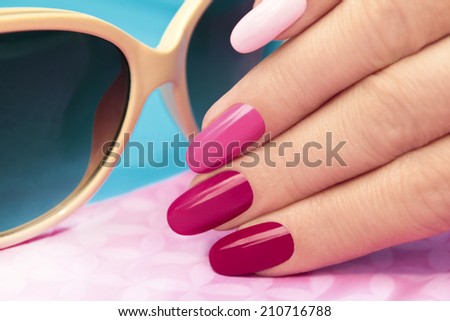 	  Pink manicure covered different in tone nail Polish on oval shaped nails. Royalty-Free Stock Photo #210716788