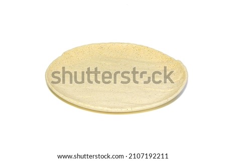 Beige plate isolated on white background. Angle view, deep depth of field, picture is in focus from front to back.