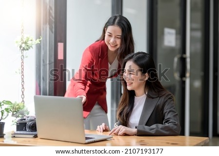 Two Young Asian businesswoman discuss with new startup project Idea presentation, analyze planning and financial statistics and investment market at office. Royalty-Free Stock Photo #2107193177