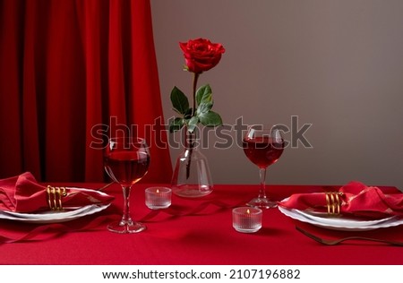 Romantic table setting with white dinnerware and red napkins, wine and candles. Valentines day or romantic dinner concept. Romantic Dinner. Royalty-Free Stock Photo #2107196882