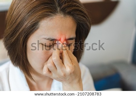 Sinus,Sinusitis, or rhinosinusitis concept. Asia woman suffer from headache, thick nasal mucus, and face pain symptoms. Royalty-Free Stock Photo #2107208783