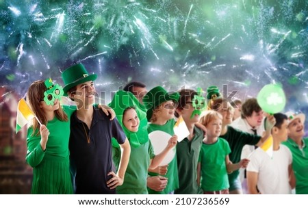St Patrick day fireworks and parade. Irish party. Group of friends and family celebrate Saint Patrick holiday on city streets of Dublin. Ireland fans celebrating with green drinks and clover leaves.