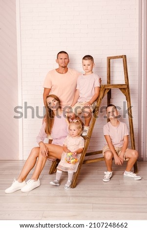 a happy beautiful family of five in light pink clothes