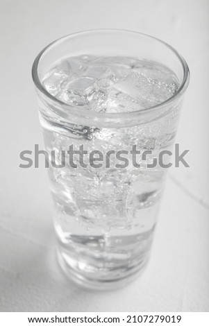 Glass of soda water on white table, closeup