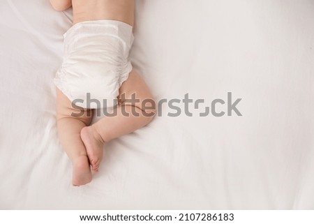 Little baby in diaper on bed, top view. Space for text Royalty-Free Stock Photo #2107286183