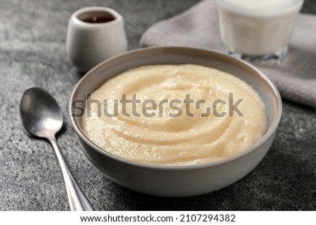 Bowl with delicious semolina pudding on grey table Royalty-Free Stock Photo #2107294382