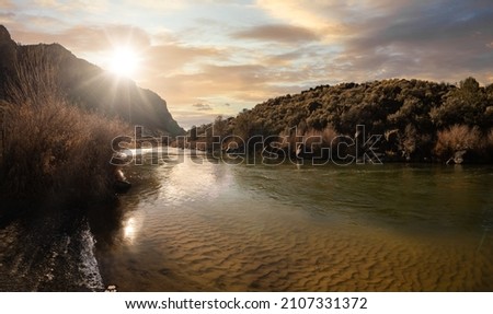vibrant sunset reflects on the waters of the riverbed on a sunny day in fall