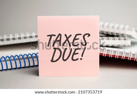 Notepad with text TAXES DUE with black marker on white background
