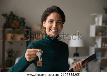 Happy young professional hispanic latin female realtor or broker holding keys and paper agreements in hands, proposing renovated news stylish apartment to client, real estate service concept. Royalty-Free Stock Photo #2107355255