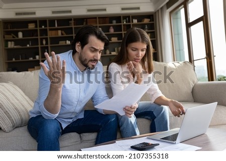 Couple reviewing bills feels stressed having financial problem, check finances, experiencing lack of money pay for loan, huge taxes, utility rates, get eviction notice, bank debt notification concept Royalty-Free Stock Photo #2107355318