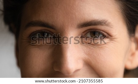 Extreme close up happy young hispanic caucasian woman with brown eyes looking at camera. Smiling millennial female client feeling satisfied with ophthalmology clinic service, eyesight laser correction Royalty-Free Stock Photo #2107355585