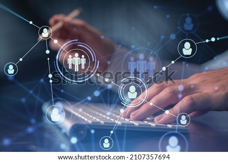 Hands of hr specialist is typing the keyboard in the internet to find the best candidates to create international network in recruitment process. Formal wear. Social media hologram icons.