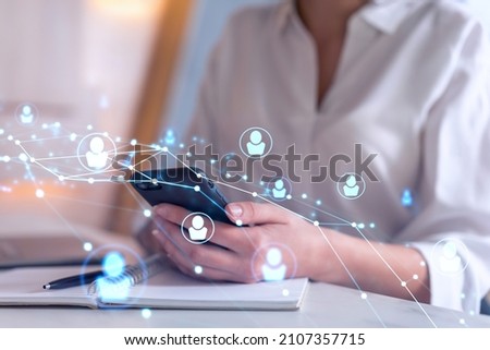 HR woman specialist in formal wear browsing social networks in the Internet in smart phone to find the best candidates to hire international team. Concept of success. Media hologram icons.