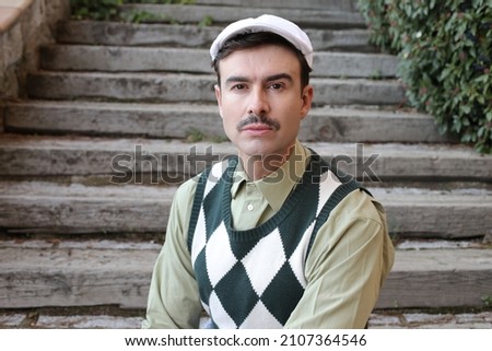 Man with a mustache wearing sleeveless rhombus sweater Royalty-Free Stock Photo #2107364546