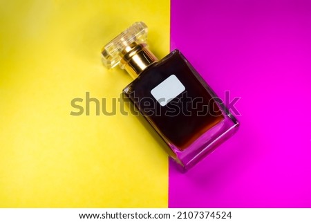luxury perfume bottle with brown liquid isolated on a purple and gold background. Perfume mockup ad template
