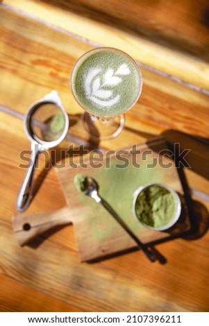 Pistachio coffee in the glass with cream or milk, top view on beautiful wooden background. Great picture for baner or menu