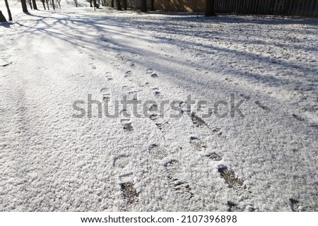 Footprint on the footpath after a snowfall in winter