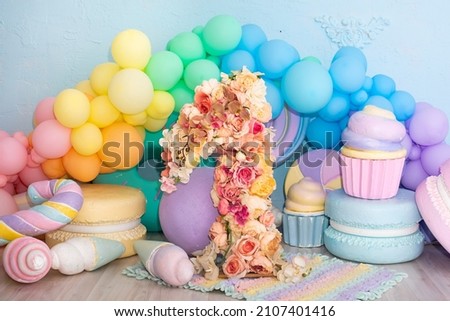 photo zone for the first birthday. balls, number 1, one from flowers. decorative sweets and cakes. pastel colors.