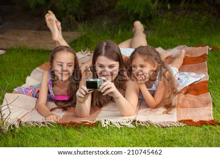Mother and two daughters making self photo at park