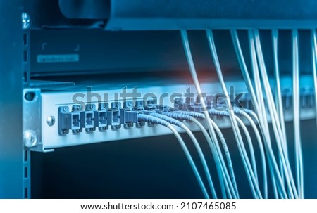 fiber optic cables plugged in network switch panel inside data center Royalty-Free Stock Photo #2107465085