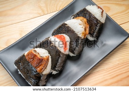 Onigiri or Japanese seaweed rice triangles shaped Stuffed with grilled eel, scallop, plum and fish roe, Japanese Rice Balls  famous food. Royalty-Free Stock Photo #2107513634