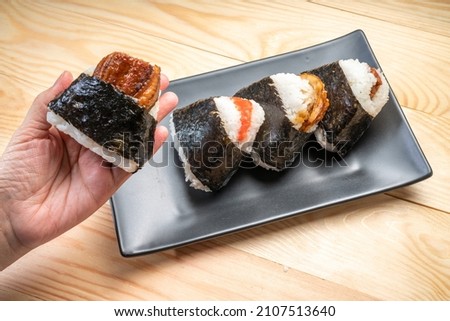 Onigiri or Japanese seaweed rice triangles shaped Stuffed with grilled eel, scallop, plum and fish roe, Japanese Rice Balls  famous food. Royalty-Free Stock Photo #2107513640