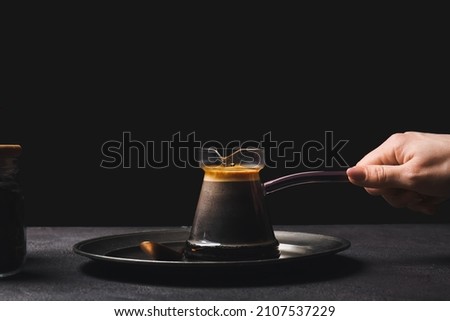 Woman with delicious turkish coffee in cezve on dark background Royalty-Free Stock Photo #2107537229