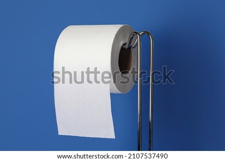 Modern holder with toilet paper roll on color background, closeup Royalty-Free Stock Photo #2107537490