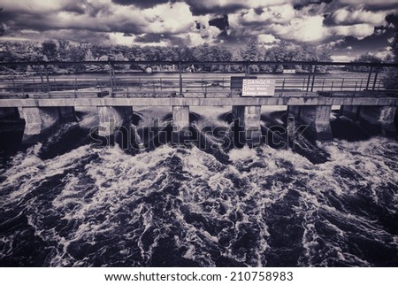 Fast flowing rushing water being purged through a dam in Bala, Ontario, Canada.  Filtered for a retro vintage look. 