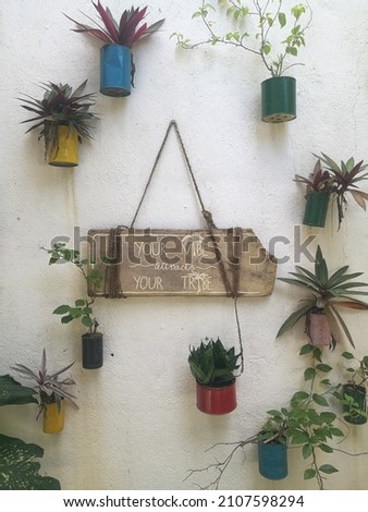 Your vibe attracts your tribe sign surrounded by plants