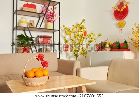 Basket of fresh ripe mandarins on table in living room as a present for Tet Royalty-Free Stock Photo #2107601555