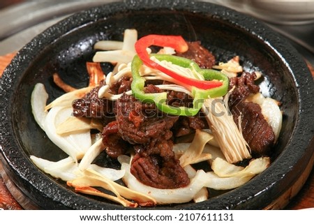Seokgalbi is a Korean food that you cook galbi and put it on a warm stone plate. Royalty-Free Stock Photo #2107611131