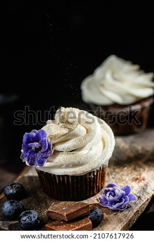 Chocolate cupcakes with blueberries on a dark table